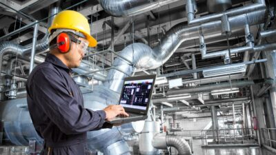 Engineer using laptop computer in factory