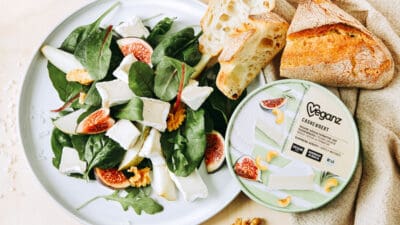 A salad with vegan cheese and baguette.