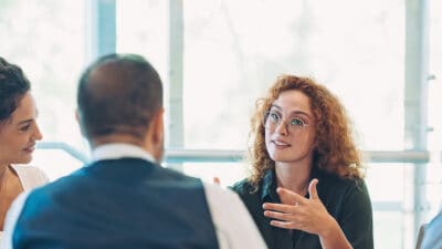 Business persons sitting around a table and talking