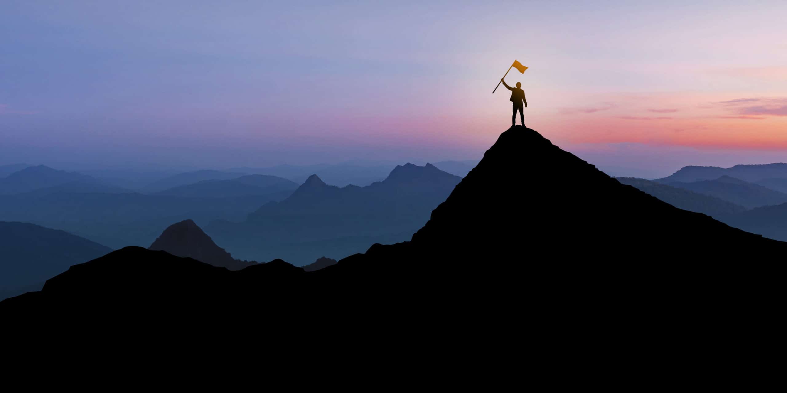 Silhouette of Businessman standing on mountain top over sunrise twilight background with flag, Winner, Success and Leadership concept